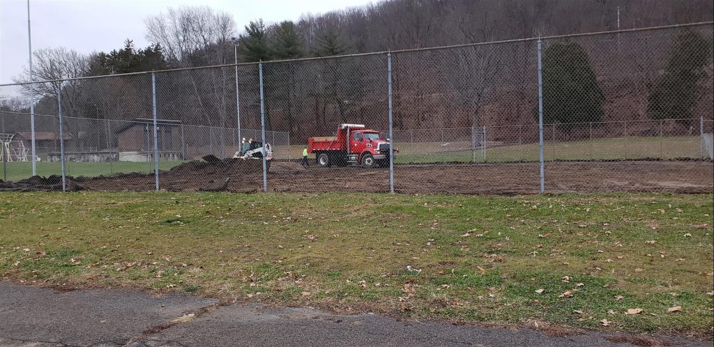 Village of Painted Post Craig Park Dog Park tennis court removal, red dump truck on mound of dirt next to white skid steer